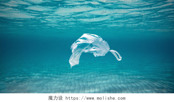 蓝色海洋中的透明塑料袋Ocean pollution concept, plastic bag floating in the water at the coral reef with copy space